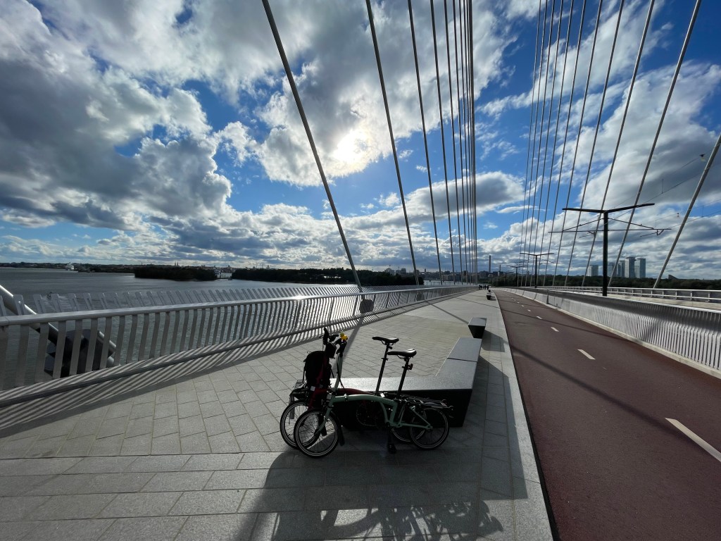 One of Helsinki's new crown bridges offering a car-free connection between city center and the island of Laajasalo. There are two bikes in the foreground, with a two-way cycle track on the right and the sea on the left.